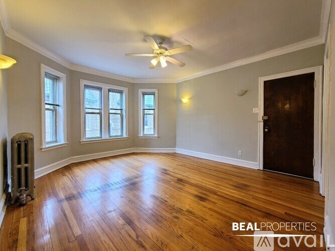 A room with wooden floors and a ceiling fan.