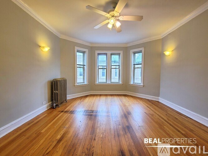 A room with wooden floors and a ceiling fan.