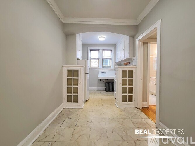 A spacious room with marble flooring and a central window.