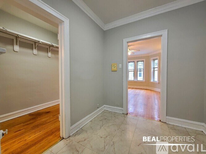 A room with a wooden floor and a doorway leading to another room.