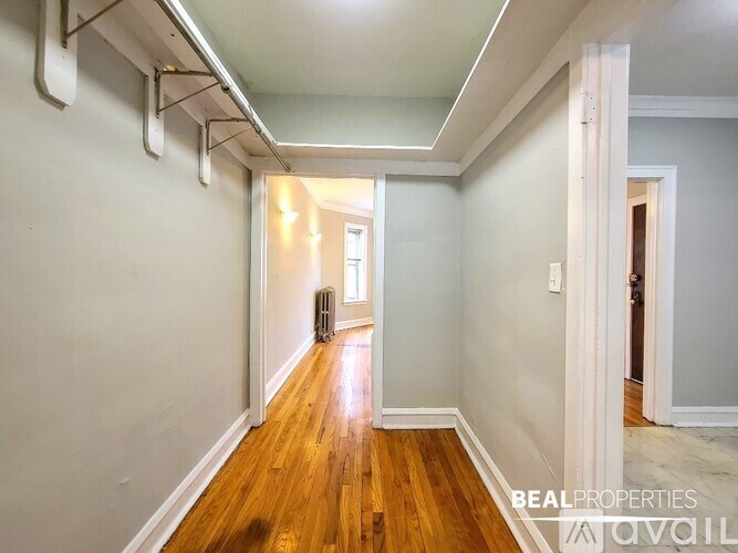 A hallway with wood floors and white walls.