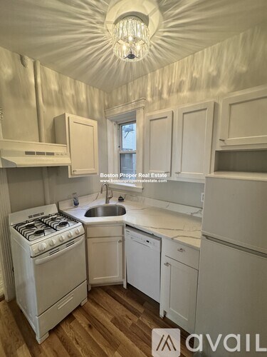 A kitchen with white cabinets and a stove top oven.