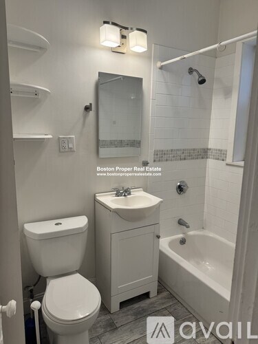A white bathroom with a toilet, sink, and bathtub.