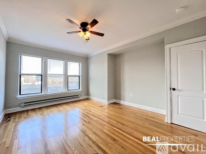 A room with a ceiling fan and wooden flooring.