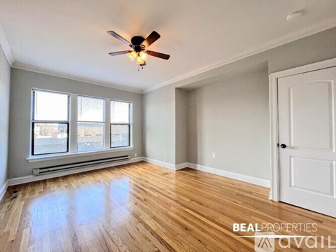 A room with a ceiling fan and wooden flooring.