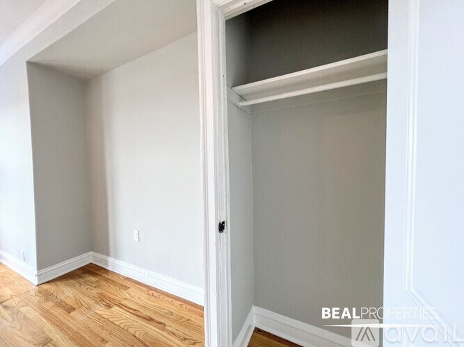 A room with a white door and a grey wall.