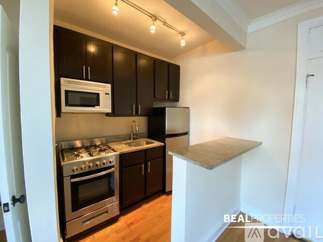 A kitchen with dark brown cabinets and stainless steel appliances.