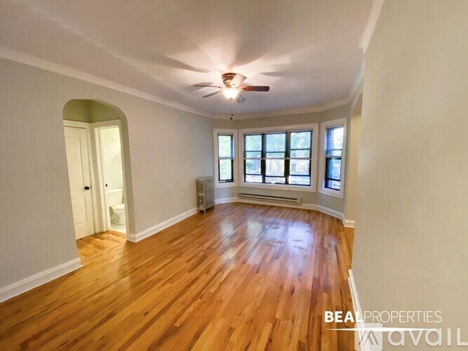 A room with wooden floors and a window with blinds.