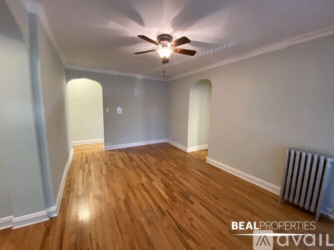 A room with wooden floors and a ceiling fan.