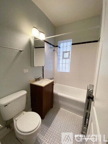 A white toilet sits next to a sink in a small bathroom.