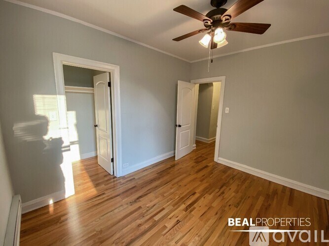 A room with a ceiling fan and wooden floors.