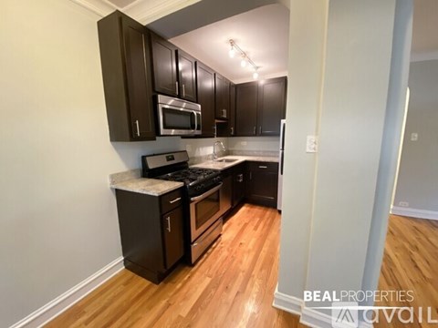A kitchen with dark wood cabinets and a white countertop.