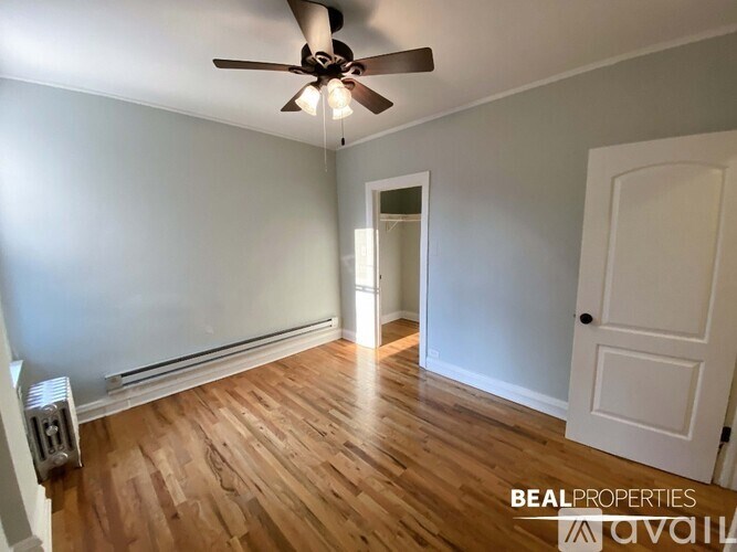 A room with a ceiling fan and wooden flooring.