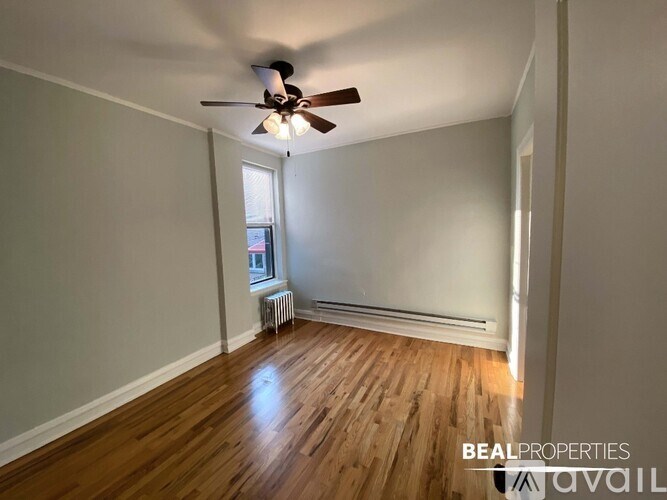A room with a ceiling fan and wooden flooring.