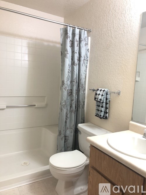 A bathroom with a toilet, sink, and shower.