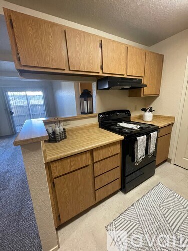 A kitchen with wooden cabinets and a black stove top oven.