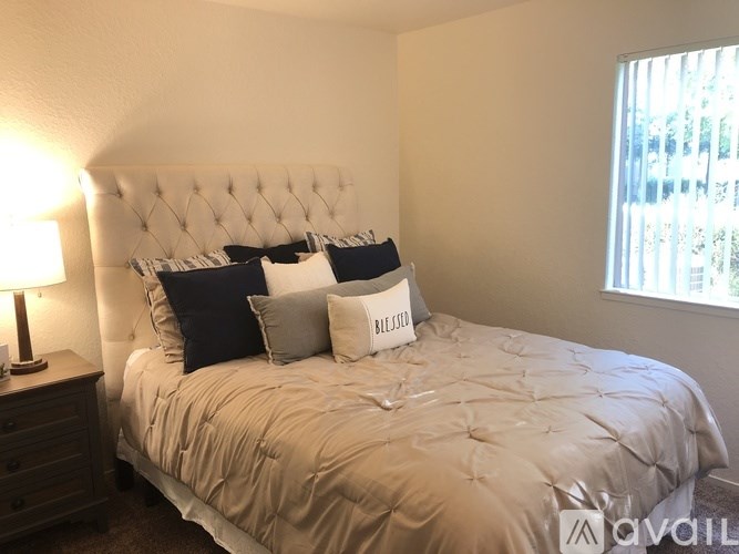 A bed with a white headboard and pillows that say "BLESSED" is in the image.