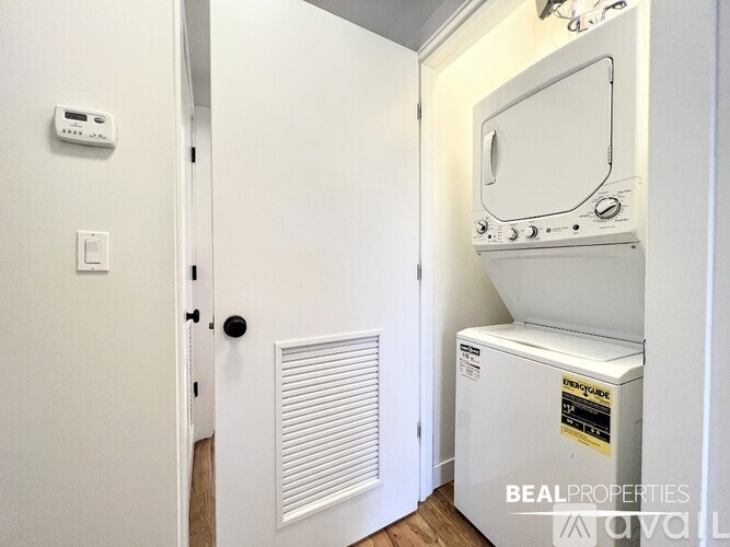 A white door with a black handle and a white wall with a thermostat on it.