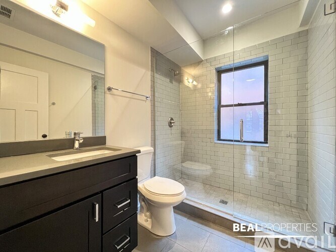 A bathroom with a toilet, sink, and a window.