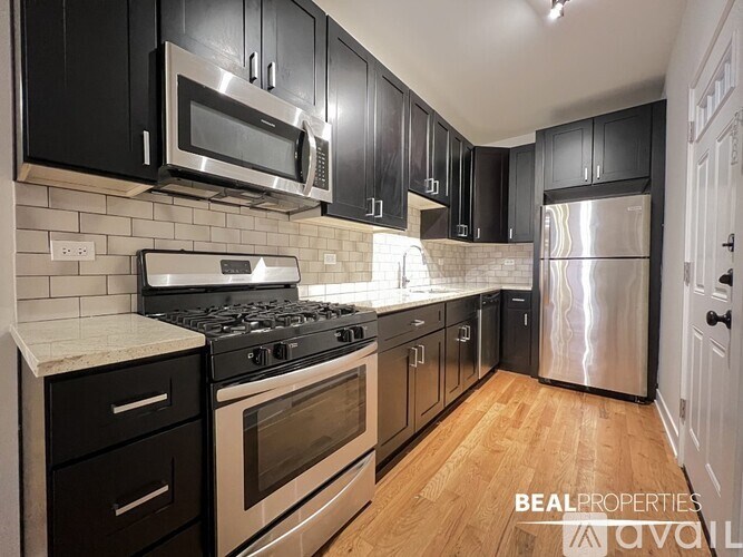 A kitchen with black cabinets and stainless steel appliances.