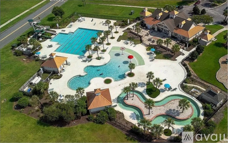 An aerial view of a resort with a large pool and a water slide.