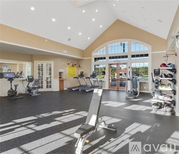 A gym with treadmills, elliptical machines, and other exercise equipment.