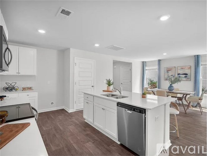 A modern kitchen with white cabinets and a wooden island.