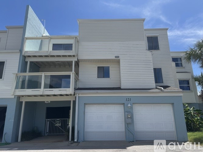 A two-story house with a garage and a balcony on the upper floor.