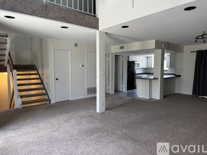 A spacious apartment with a staircase leading to the upper floor.