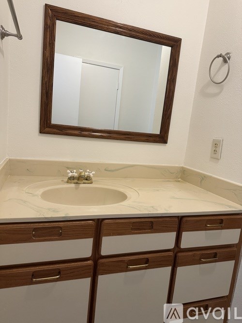 A bathroom sink with a mirror above it and drawers below.