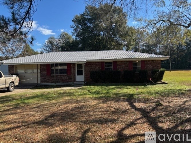 A house with a red door and a white truck parked in front.