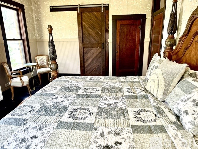 A bed with a quilt and a pillow is in the foreground of the image.
