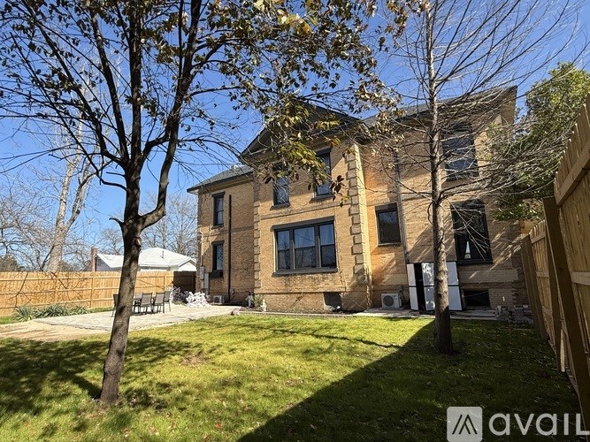 A house with a yard and a tree in front of it.