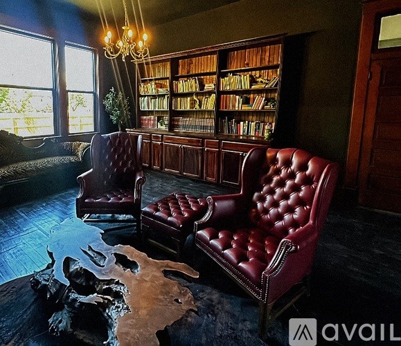 A room with a red leather chair and a cowhide rug.