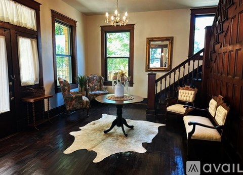 A living room with a white cowhide rug and a chandelier.
