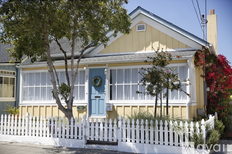A yellow house with a white picket fence.