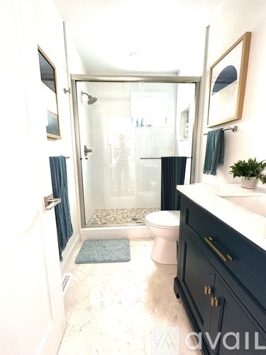 A bathroom with a toilet, sink, and shower.