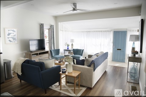 A living room with a dark blue chair and a white couch.