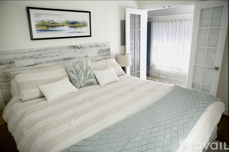 A bed with a white headboard and a blue and white bedspread.