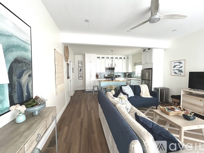 A living room with a couch, a coffee table, and a television.