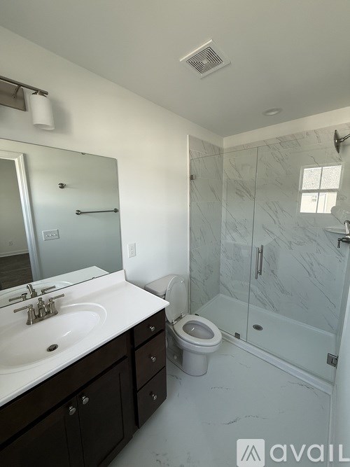 A bathroom with a sink, toilet, and shower.