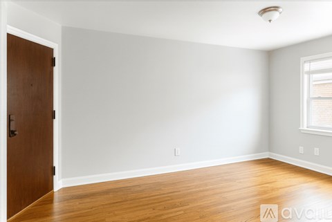 A room with a wooden floor and a brown door.