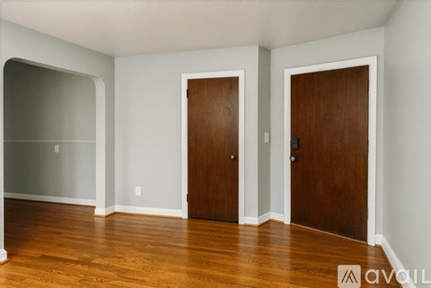 A room with two brown doors and a white wall.