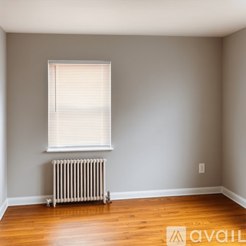 A room with a window and a radiator on the floor.