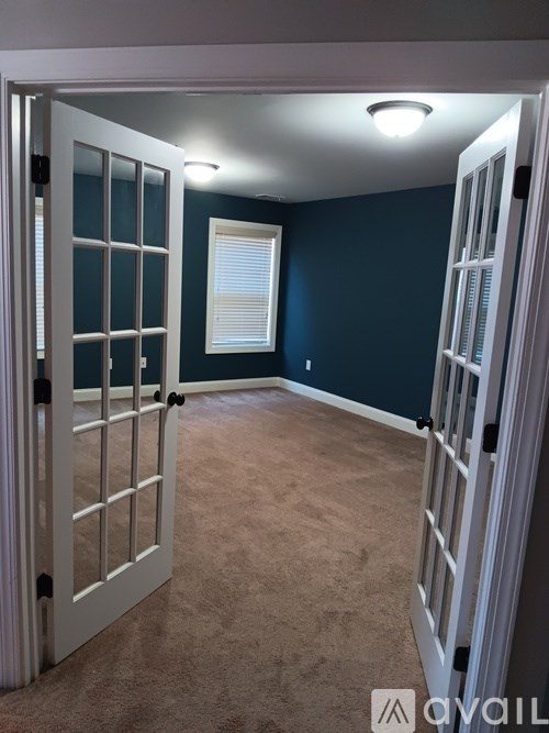 A room with a carpeted floor and a white door.