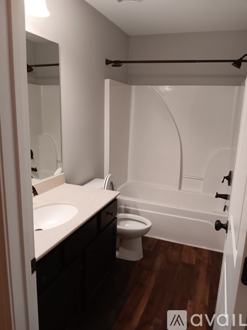 A bathroom with a toilet, sink, and bathtub.