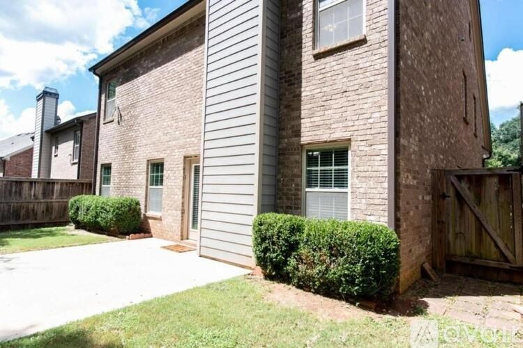 A house with a grey garage door and a brick wall.