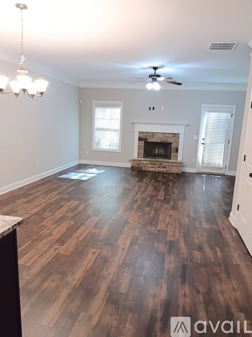 A living room with a fireplace and wood flooring.