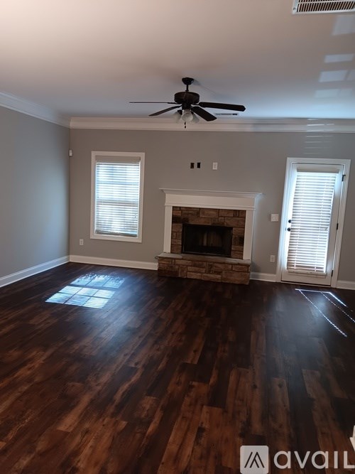 A room with a fireplace and wood flooring.