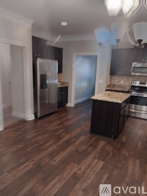 A kitchen with a refrigerator, microwave, and oven.